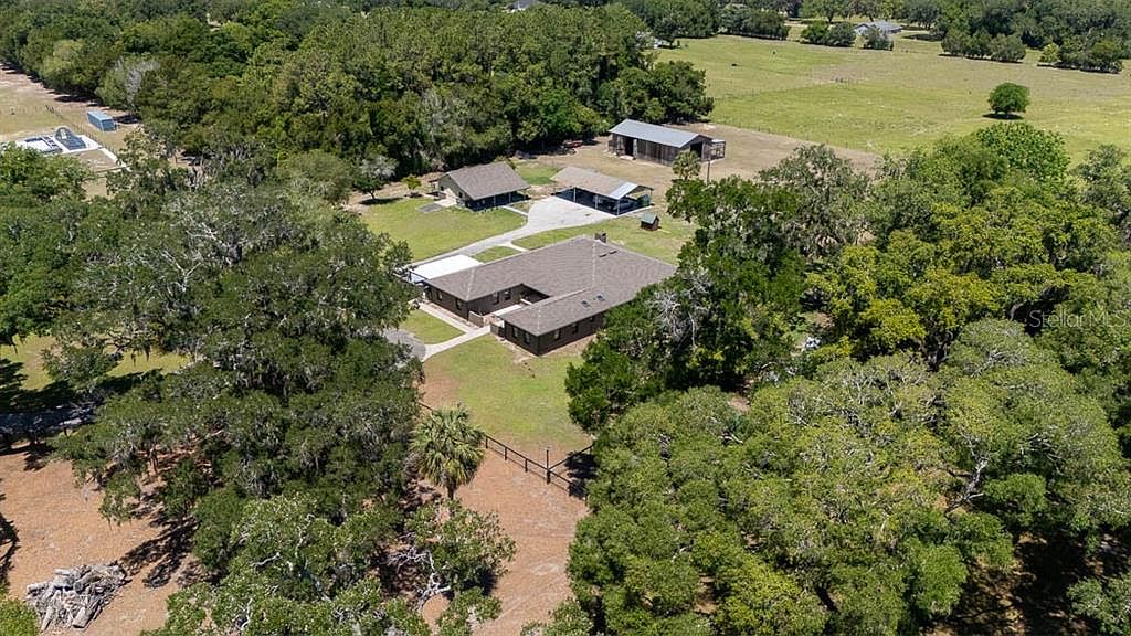Aerial of the home and surrounding fields with the workshop and barn in the distance