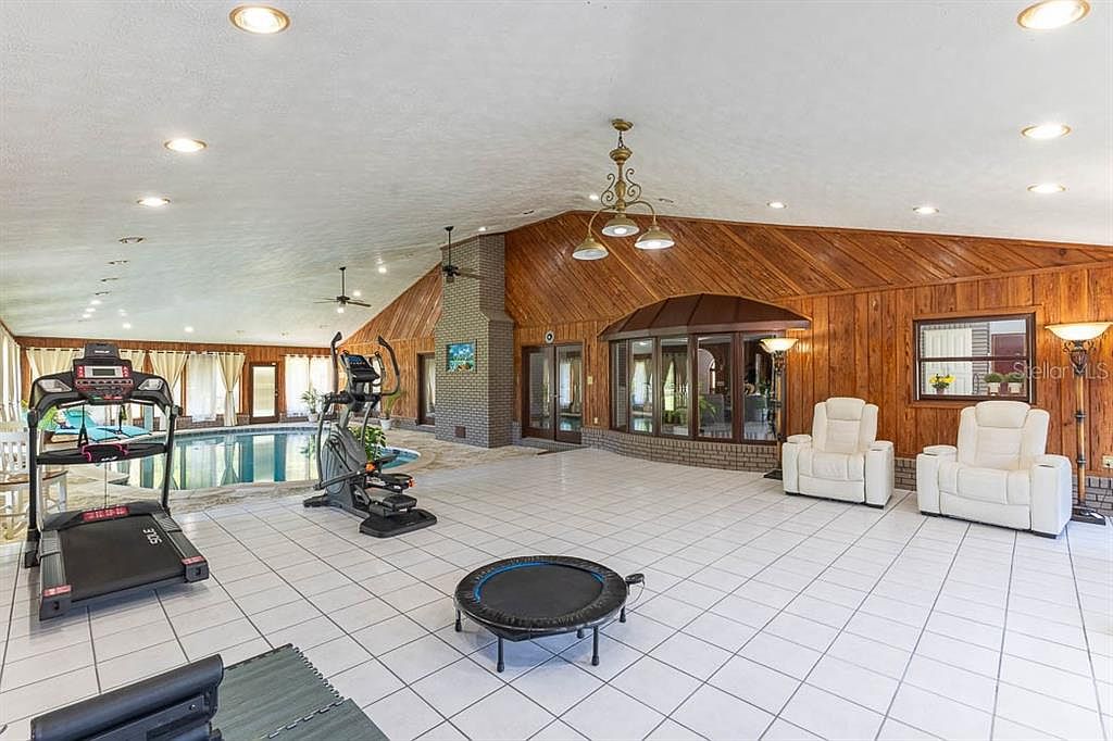Indoor pool wing wide view with vaulted ceiling and pine paneling