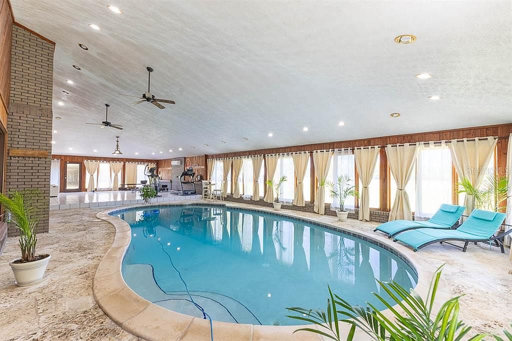 Indoor pool with curved coping and floor-to-ceiling windows